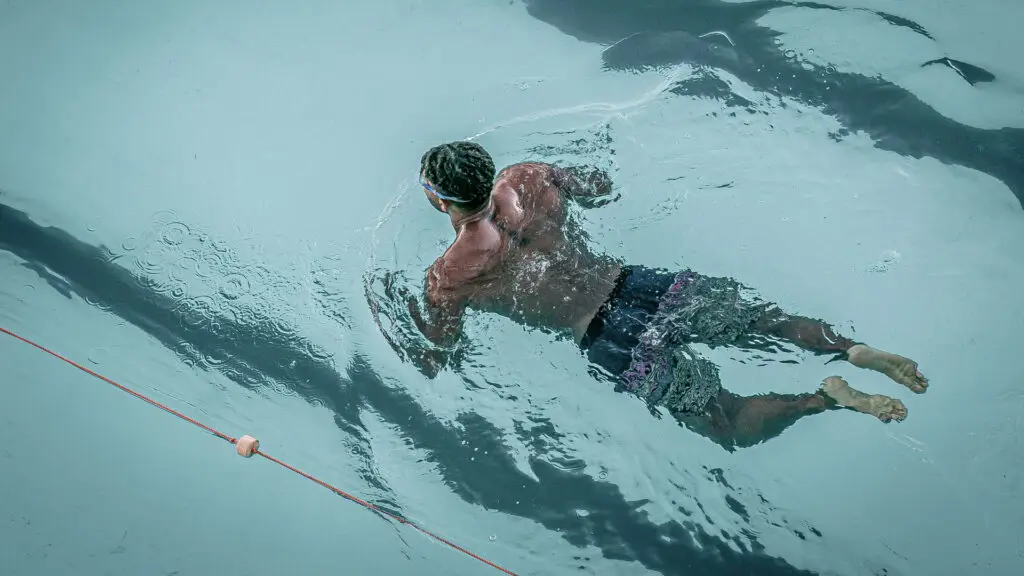 A person swimming in a clear blue pool