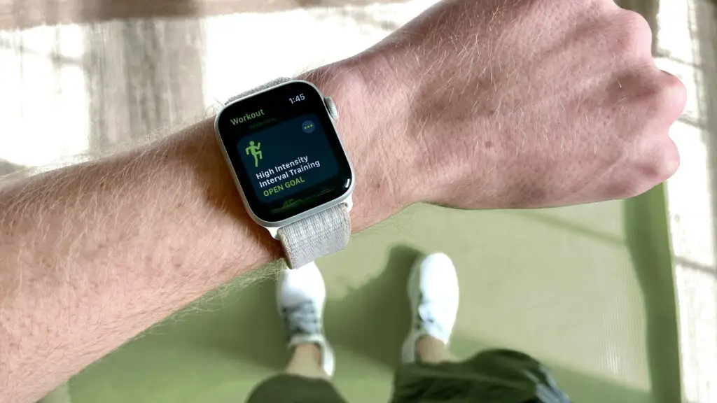 A fitness tracker on someone's wrist showing steps or workout progress.