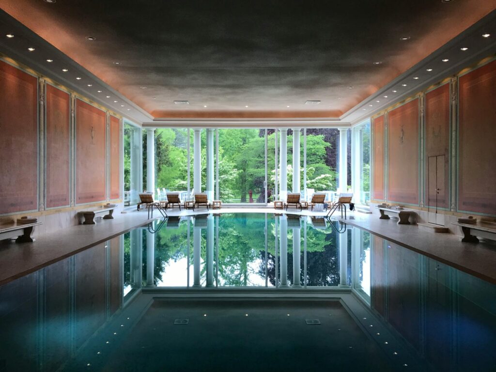Elegant indoor hotel pool with natural light and classic European design features