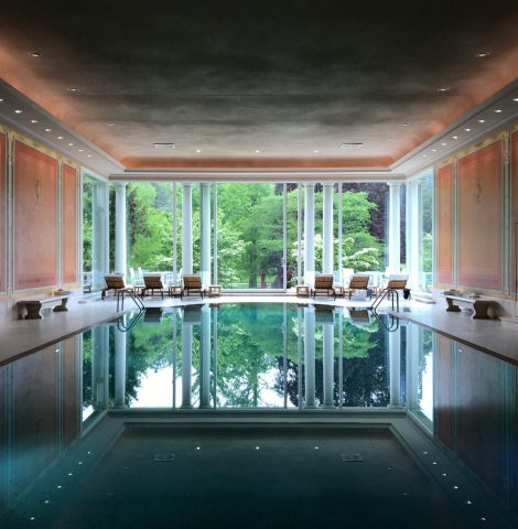 Elegant indoor hotel pool with natural light and classic European design features